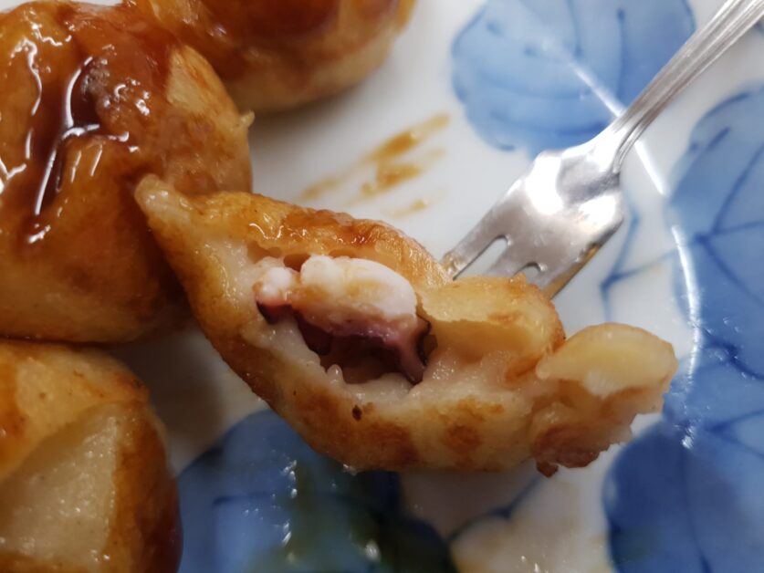 close up of takoyaki with octopus chunk