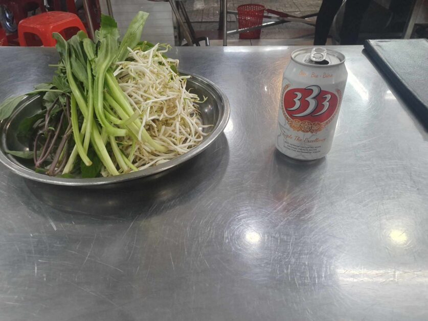 A can of 333 Beer with pho vegetables