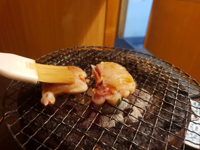 fugu sumibiyaki being basted with soy sauce