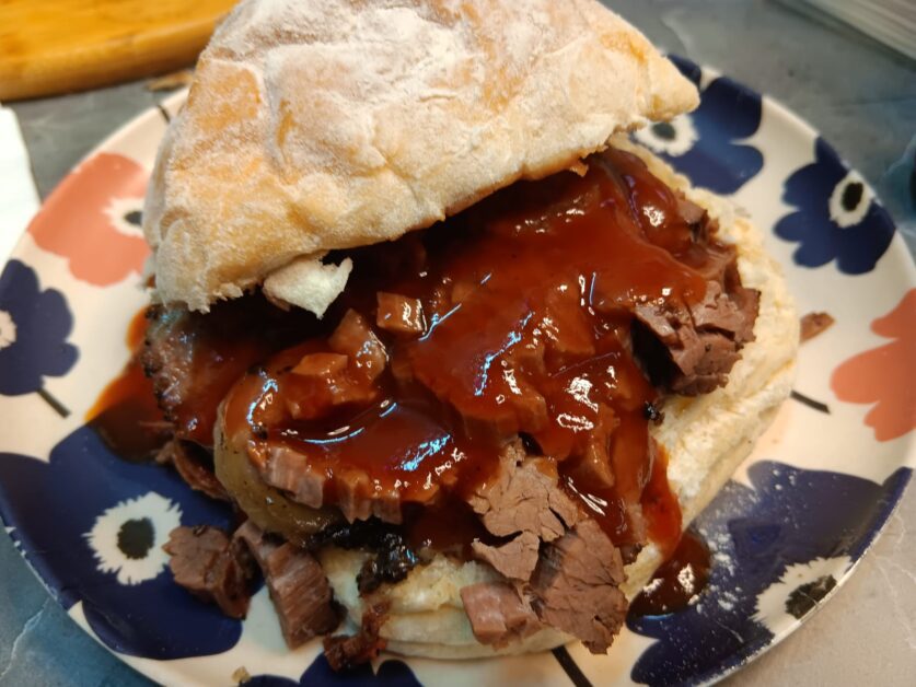 Rossi's beef brisket sandwich spilling out of bap