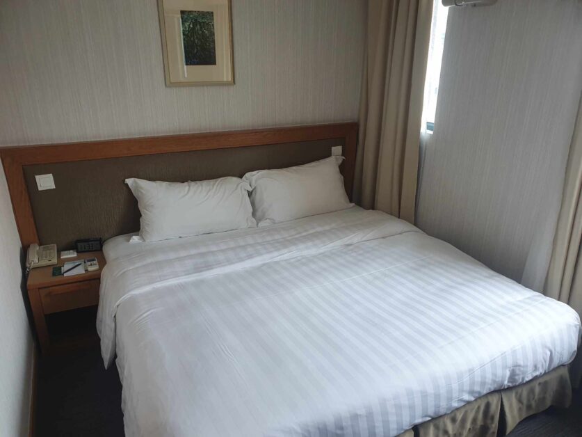 Deluxe room bed at Bishop Lei International House