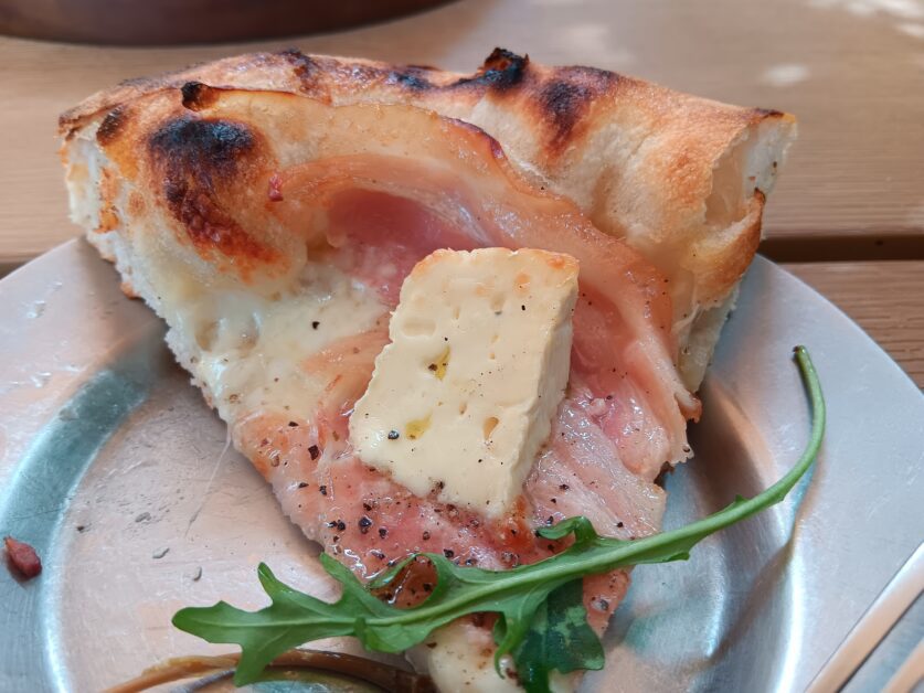 slice of porchetta and camembert pizza at Hygge