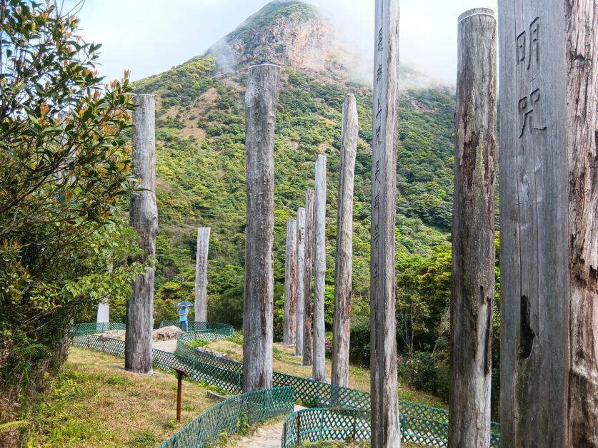 wooden monuments with Heart Sutra prayer with Lantau Peak backdrop